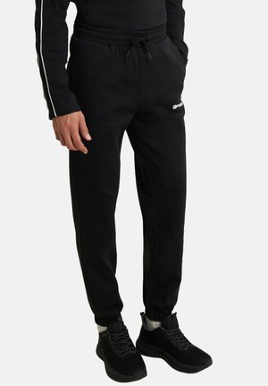 Pantaloni sportivi neri con una vestibilità rilassata, dotati di una vita elastica con cordoncino, polsini alle caviglie e un piccolo logo bianco sulla tasca.