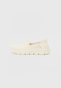 Pantofi crem slip-on cu un superior tricotat și detalii din plasă, o talpă intermediară groasă albă și o talpă texturată pentru o aderență crescută.