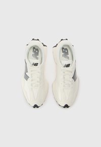 Sneakers with a white and black design, featuring a smooth leather upper, contrasting side accents, and a treaded sole for traction.