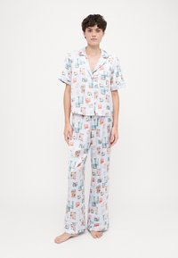 Ensemble de pyjama en deux pièces réalisé en tissu doux ; présente un fond bleu clair avec un motif répété d'illustrations colorées. Haut à manches courtes et pantalon long.