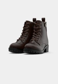 Brązowe skórzane botki za kostkę na sznurówki z teksturowanym wykończeniem, okrągłym noskiem oraz masywną czarną gumową podeszwą, wyposażone w boczne zamki błyskawiczne i metalowe akcenty.