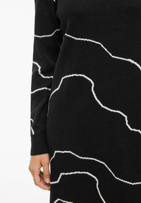 Abito nero in maglia con motivi astratti bianchi, scollatura tonda e polsini a contrasto. Tessuto morbido con una vestibilità confortevole.