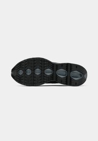 Suela de zapatilla deportiva negra con un patrón texturizado, que presenta aberturas hexagonales y un diseño segmentado para tracción y soporte.