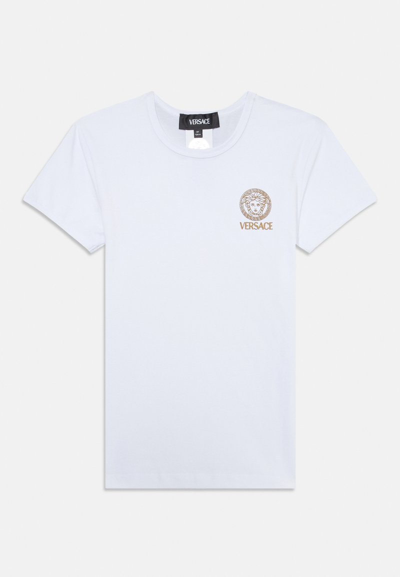 Bílá bavlněná tričko s kulatým výstřihem, krátkými rukávy a zlatě potištěným logem Medusa s kruhovým okrajem na levé hrudi.