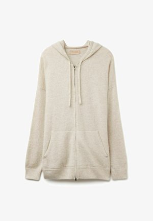 Beżowa bluza rozpinana z miękkiej, teksturowanej tkaniny. Posiada kaptur ze sznurkiem, dwie przednie kieszenie oraz ściągacze przy mankietach i u dołu.