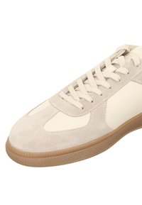 Sneaker in suede grigio chiaro con accenti crema, caratterizzata da una punta rotonda, suola in gomma testurizzata e lacci piatti in cotone.
