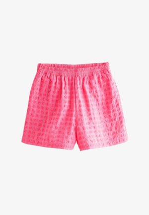 Jasnoróżowe szorty z elastycznym pasem, ozdobione delikatnym wzorem w kwadraty, o luźnym kroju i długości do połowy uda.
