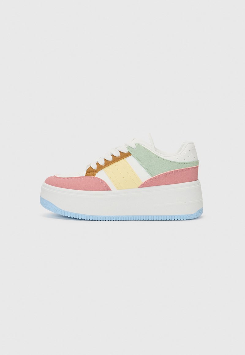 Baskets à plateforme avec des panneaux multicolores : rose, jaune, vert et marron. Fabriquées en textile et en daim, avec des lacets blancs et une semelle bleu clair.
