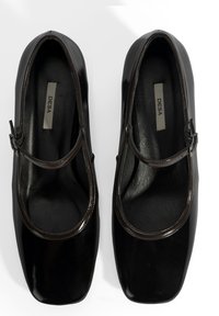 Schwarze Lackleder-Mary-Jane-Schuhe mit quadratischen Zehen, abgerundeten Kanten und einem dünnen Riemen über dem Spann. Gepolsterter Innenraum mit Logo.