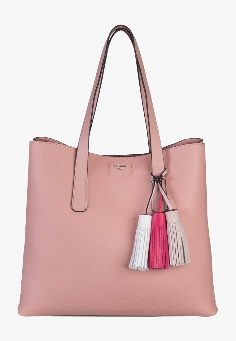 Różowa skórzana torba tote z dwoma ramiączkami, otwartym wierzchem oraz trzema dekoracyjnymi frędzlami w kolorze białym, różowym i jasnoróżowym. Szczegół z logo w kolorze srebrnym.