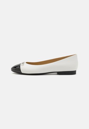 Ballerines en cuir blanc avec un embout en vernis noir. Présente un accent argenté à l'avant, un petit talon noir, et une texture lisse.