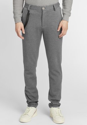 Gray tapered trousers made of textured fabric, featuring a button closure, side pockets, and a chain accent on the waistband.