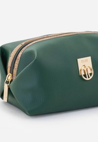 Borsa cosmetica in pelle verde con superficie testurizzata, accessori in tonalità oro e cerniera con accento floreale. Presenta una forma ovale strutturata.