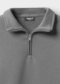 Grijze ritssweater met ribgebreide kraag, textuurstof en metalen rits. Heeft een label met "BUROCS" en maat "M."