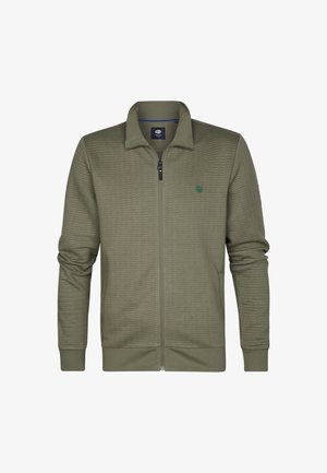 Veste zippée vert olive avec une finition texturée, col plat et poignets élastiques. Présente un petit logo sur la partie gauche de la poitrine.