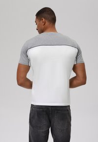 Gray and white short-sleeve t-shirt with a contrasting shoulder design. Smooth texture, fitted shape, with black accent stitching along the seams.