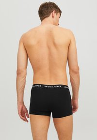 Boxer neri con cintura con marchio, caratterizzati da un design aderente. Il materiale sembra liscio ed elastico.