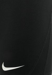 Czarne spodenki sportowe wykonane z elastycznego materiału o gładkiej fakturze. Posiadają białe logo Nike umieszczone w dolnej lewej części.