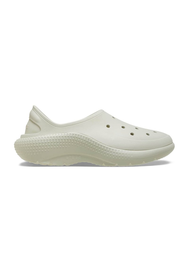 Light beige clogs made of flexible, textured material. Features ventilation holes and a cushioned sole with a dotted pattern for grip.