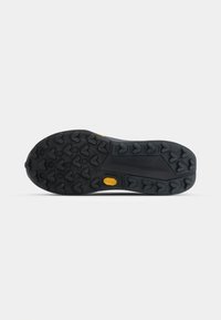 Black rubber shoe outsole with a textured tread pattern featuring heart-shaped lugs and a prominent yellow Vibram logo.