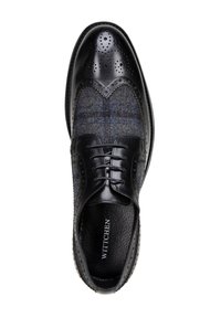 Zwarte leren schoen met brogue-details, voorzien van een grijs geruite bovenkant en vetersluiting. Perforatie-accenten en een gestructureerde voering.