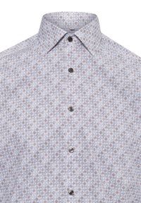 Chemise à boutons, avec une base blanche ornée d'un motif floral bleu et orange, col pointu et boutons foncés. Texture du tissu lisse.