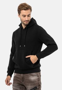 Schwarzer Kapuzenpullover mit einer vorderen Kängurutasche, Kordelzug, gerippten Bündchen und einer weichen Textur.