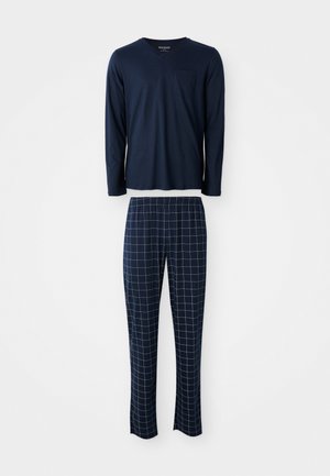 Top bleu marine à manches longues et col en V avec poche poitrine, associé à un pantalon bleu marine à motifs quadrillés blancs et taille élastique.