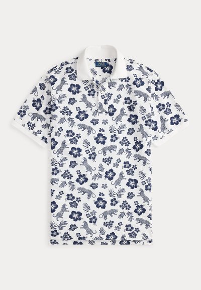 Λευκό πόλο μπλουζάκι με μοτίβο ναυτικού μπλε λουλουδιών και λεοπάρδαλης. Κλασικός γιακάς και κοντά μανίκια. Μαλακό, διαπνέον ύφασμα.