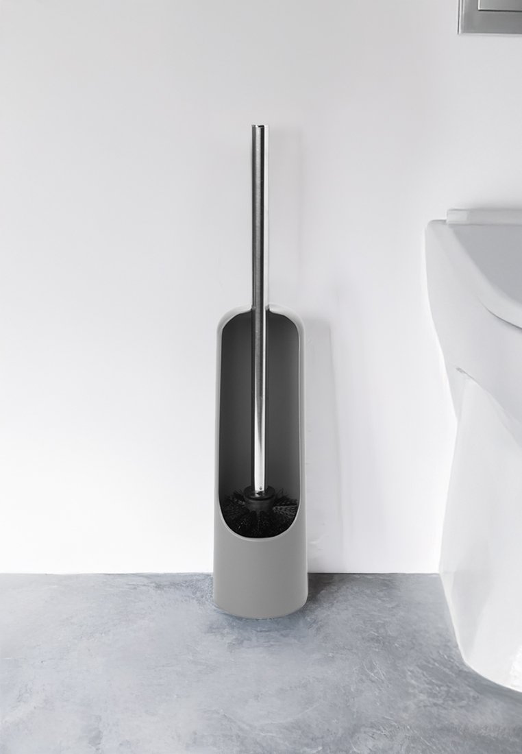 Grauer Kunststoff-Toilettenbürstenhalter mit einem langen Edelstahlgriff. Die Basis verfügt über eine runde Borstenbürste, die zum Reinigen zugänglich ist.
