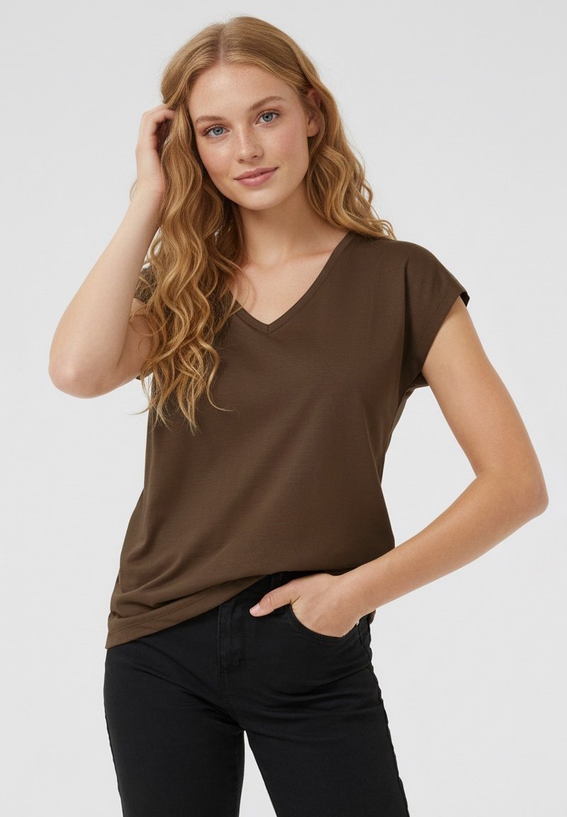 Brun t-shirt med V-ringning och korta ärmar, gjord av mjukt tyg. Bärs med svarta byxor med avslappnad passform och enkel design.