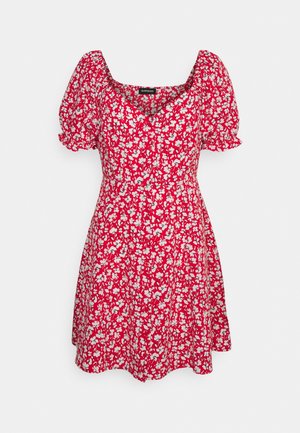 Červené mini šaty s bílým květinovým vzorem, s krátkými puff rukávy a srdcovým výstřihem.