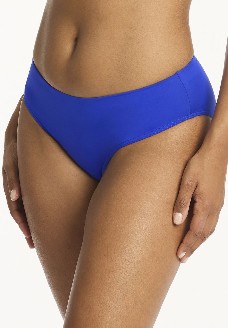 Niebieskie bikini dolne o gładkiej teksturze i umiarkowanym kryciu. Posiada prosty, bezszwowy fason bez widocznych elementów metalowych czy wzorów.