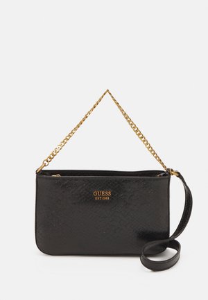 Sac à main Guess noir texturé avec poignée chaîne dorée et bandoulière noire amovible, texte du logo doré au centre devant.