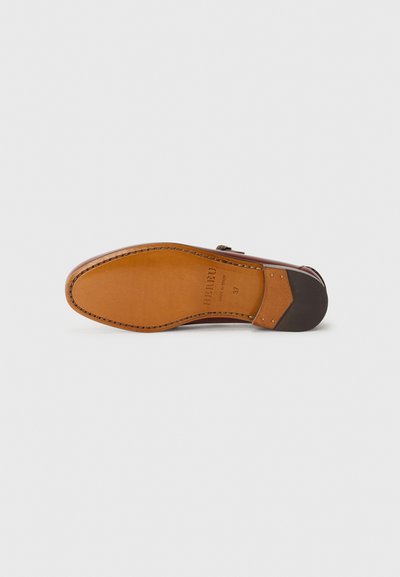 Brown leather shoe sole with a smooth texture, featuring a rounded shape, light tan color, and a darker brown accent at the heel.