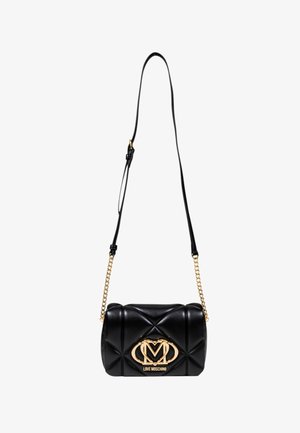Bolso bandolera de piel sintética negra acolchada con herrajes en tono dorado, que presenta un detalle de logotipo prominente y una correa con acento de cadena.