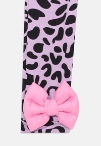Lilla tights med svart leopardmönster, med en stor rosa rosett detaljerat vid ankeln. Mjuk tyg med en slät textur.