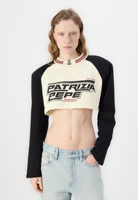 Kroppad sweatshirt med krämfärgad front och svarta ärmar. Har en iögonfallande "PATRIZIA PEPE" grafik, röda accenter och ribbad krage.