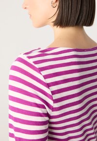 Lila- und weiß gestreifter Strickoberteil mit rundem Ausschnitt und kurzen Ärmeln, mit glatter Textur und taillierter Silhouette.