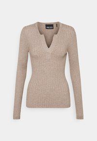 Haut beige à manches longues à côtes avec un décolleté en V et une petite touche carrée au niveau du col, fabriqué dans un matériau tricoté doux et texturé.