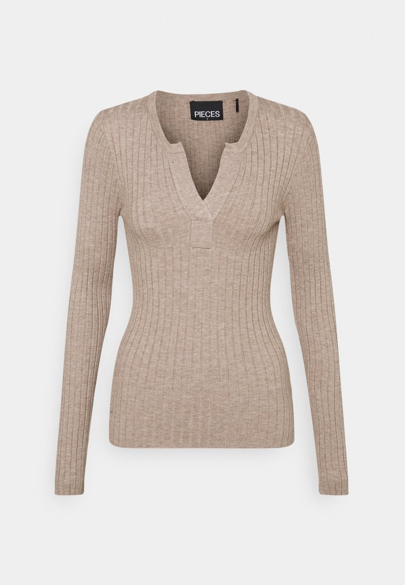 Haut beige à manches longues à côtes avec un décolleté en V et une petite touche carrée au niveau du col, fabriqué dans un matériau tricoté doux et texturé.