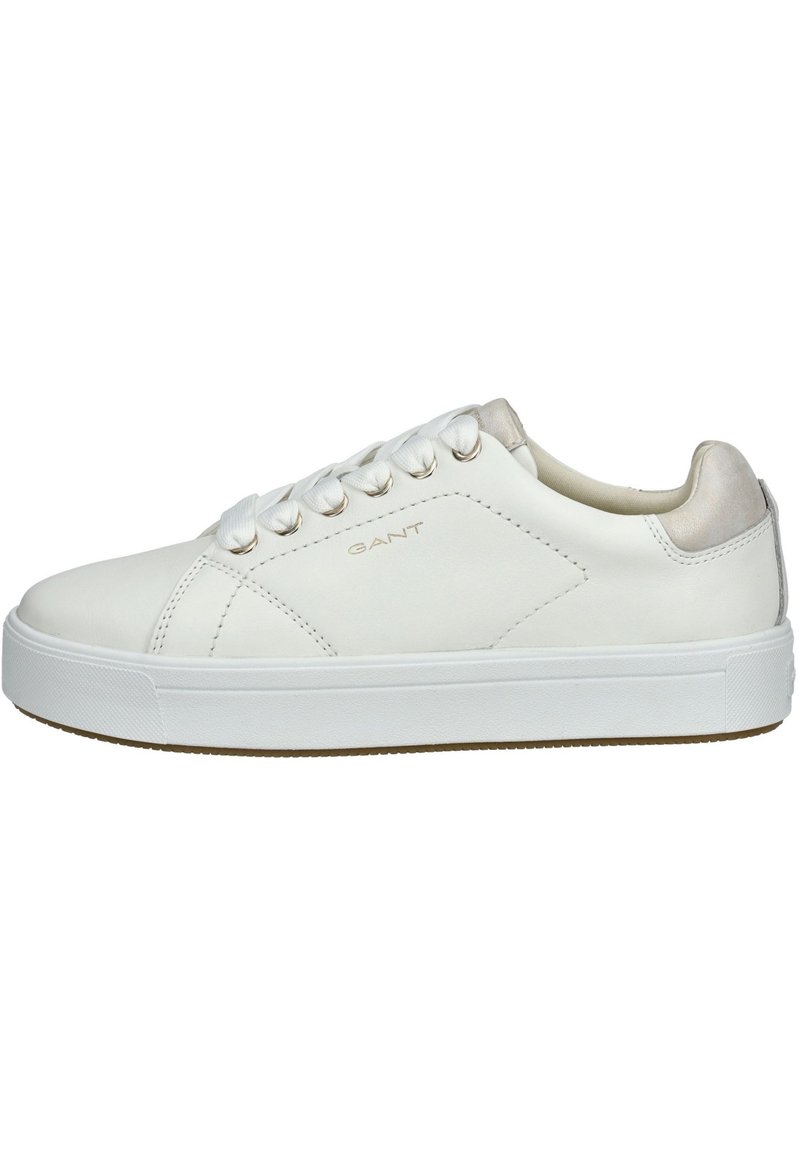 Białe skórzane sneakersy o gładkiej teksturze, zaokrąglony czubek, kontrastujące beżowe akcenty na pięcie i płaska biała gumowa podeszwa.