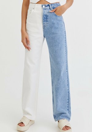 Two-tone jeans featuring a white left leg and a light blue denim right leg, with a straight fit and a high-rise waistband.