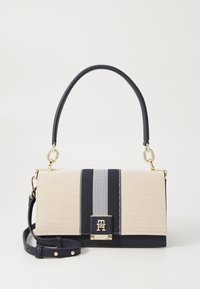 Canvas-Handtasche in Beige mit einem marineblauen Streifen. Verfügt über einen oberen Griff, goldene Beschläge und einen abnehmbaren Schultergurt. Strukturierte Oberfläche.