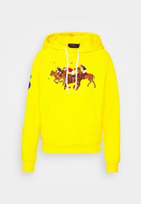 Sudadera amarilla de algodón con bolsillo frontal, que presenta un gráfico de polo de caballo y detalles en azul en las mangas.