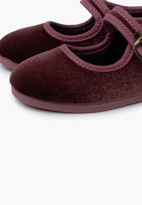 Zapatos estilo Mary Jane de terciopelo burdeos con punta redondeada, correa a juego y suela texturizada. Presentan un borde cosido y un acento de hebilla.