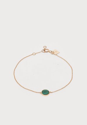 Aranyszínű lánc karkötő, középen egy ovális zöld kővel, miltérrel záródik, és extra hosszabbító hurkokkal is rendelkezik a méret állításához.