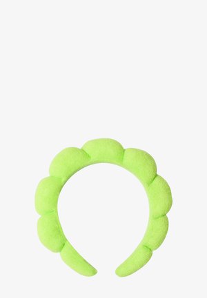 Zielony, wyściełany opaska na głowę z falistym wzorem, wykonana z miękkiego materiału. Posiada gładką fakturę i zaokrąglone krawędzie dla większego komfortu.