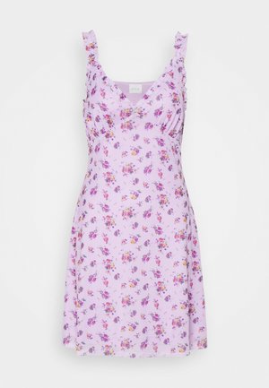 Robe lavande avec motif floral, bretelles à volants et décolleté en V. Tissu doux avec un design léger et fluide. Ourlet à hauteur du genou.