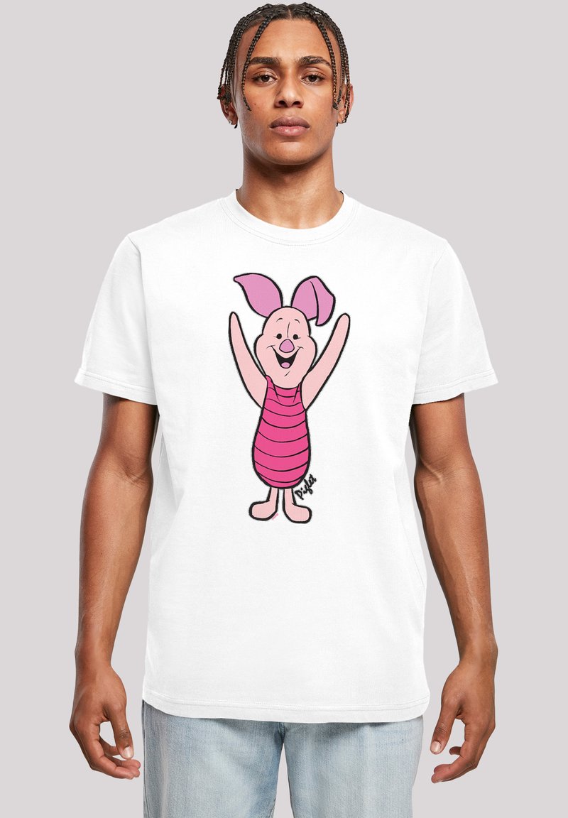 T-shirt blanc affichant un personnage de cochon de dessin animé avec une peau rose, de grandes oreilles et des vêtements rayés roses, souriant avec les bras levés.